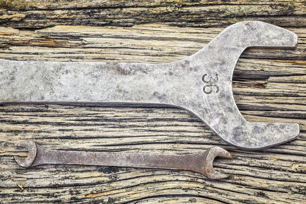 Twee vintage metalen steekringsleutels op oude houten tafel — Stockfoto