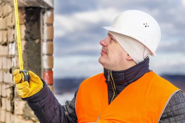 Arbetare med måttband nära byggnaden — Stockfoto