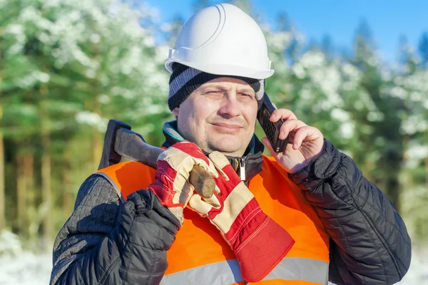 Holzfäller telefoniert mit Handy im Wald — Stockfoto