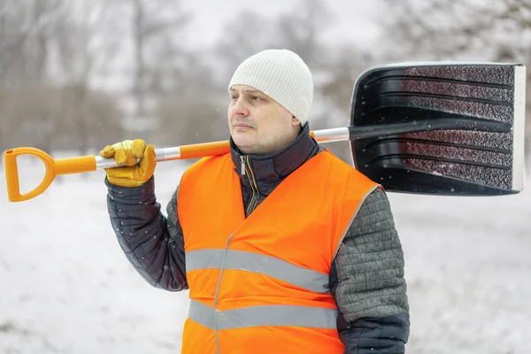 Trabalhador com pá de neve no inverno — Fotografia de Stock