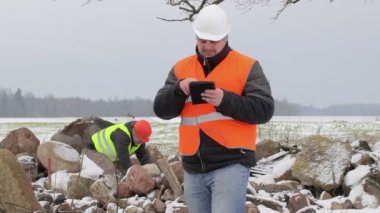 İşçiler yakınındaki taş yığınları