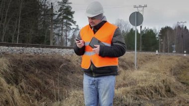 Demiryolu çalışanın cep telefonu ve tablet Pc ile