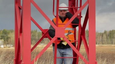 İşçi ile cep telefonu yakınındaki metal yapılar