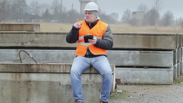 Ingénieur avec tablette PC assise sur les panneaux de béton — Video