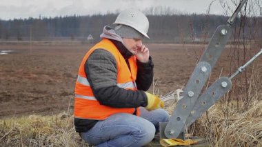 İşçi ile cep telefonu ve Gergi yakınındaki ayarlanabilir anahtarı