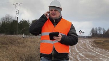Sinyal işaretleri önce cep telefonuyla konuşurken demiryolu çalışanı