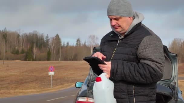 Muž s tablet Pc a prázdnou plechovku čekání na pomoc u auta — Stock video