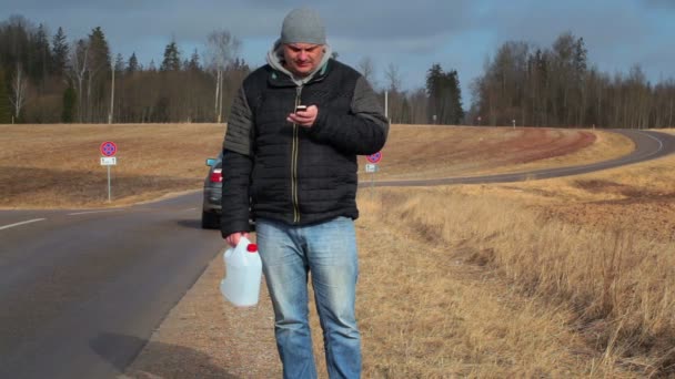 Man with cell phone and empty can waiting for help near car — Stock Video