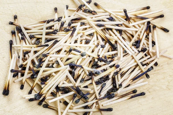 Burnt matches stack with burning match on wood — Stock Photo, Image