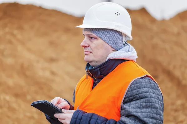 Engenheiro civil com tablet PC em uma pilha de areia — Fotografia de Stock