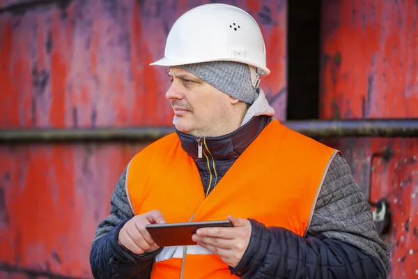 Arbeiter mit Tablet-PC nahe der roten Metalltür — Stockfoto