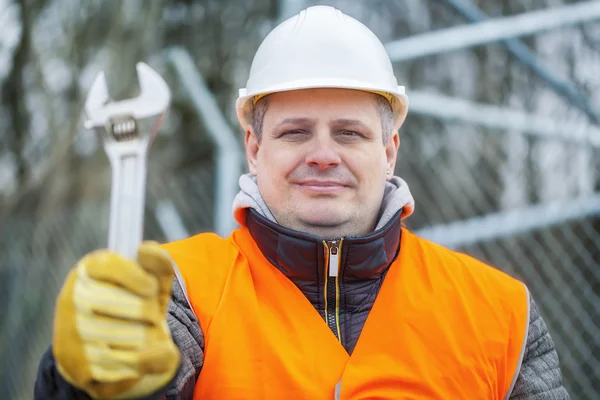 Worker with adjustable wrench at outdoors — Stock Photo, Image