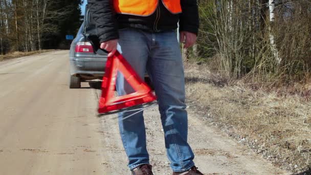 Hombre nervioso con triángulo de advertencia en la carretera cerca del coche — Vídeos de Stock