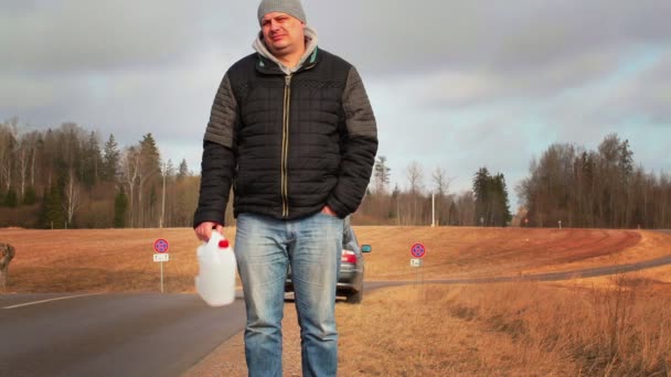 Homem com lata vazia esperando por ajuda perto de carro na estrada — Vídeo de Stock