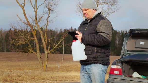 Hombre cerca de coche en busca de información en la tableta PC — Vídeo de stock