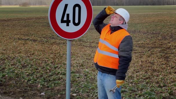 Werknemer werken met verstelbare sleutel in de buurt van verkeersbord — Stockvideo