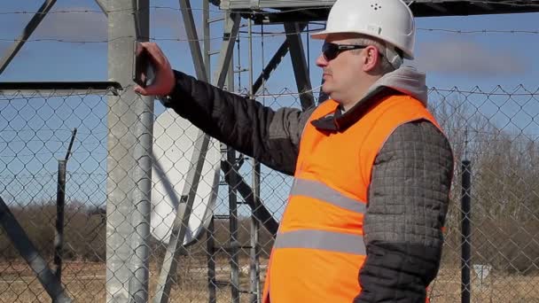 Ingenieur gefilmd in de open lucht in de buurt van metalen constructiewerken — Stockvideo