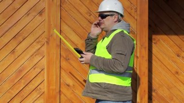 Bir mezura ve cep telefonu ile mühendis
