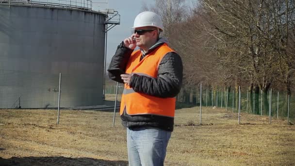 Инженер говорит по мобильному телефону на заводе — стоковое видео