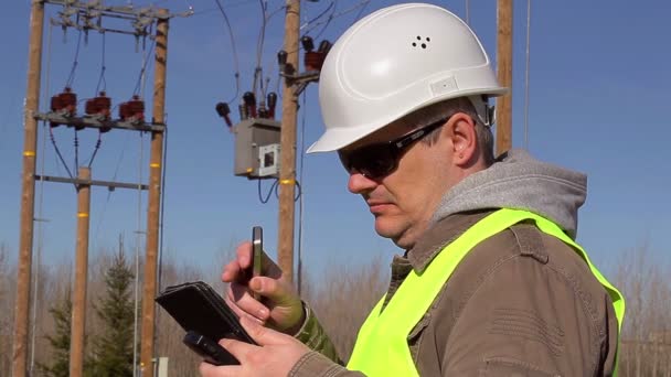 Engenheiro elétrico com PC apresentado e telefone celular ao ar livre — Vídeo de Stock