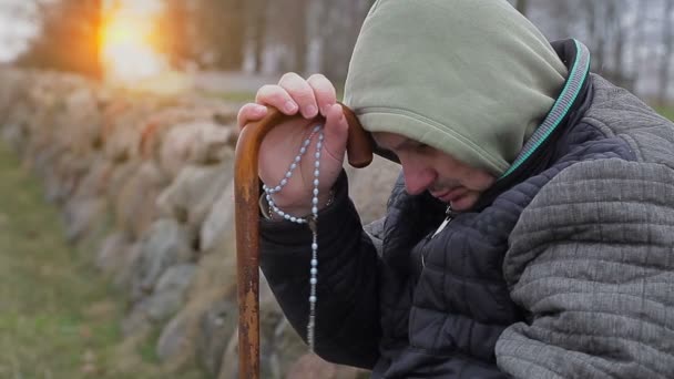 Человек с четками и тростью — стоковое видео