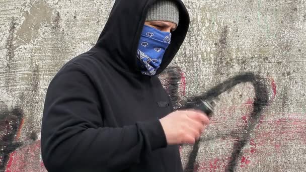 Человек трясет цветной баллончик возле стены — стоковое видео