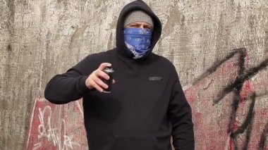 Renk sprey sallayarak adam açık havada duvara yakınındaki