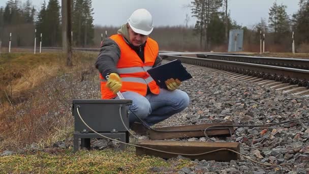 Železniční zaměstnanec s nastavitelným klíčem poblíž railway — Stock video