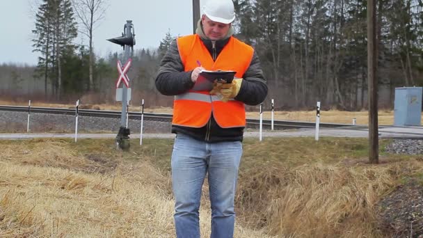 Empleado ferroviario con documentos al aire libre cerca del ferrocarril — Vídeos de Stock