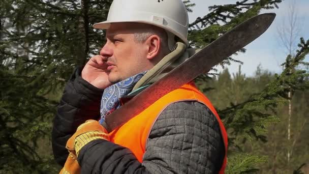 Travailleur avec téléphone portable et machette en forêt — Video