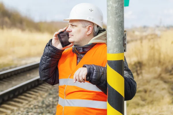 Empleado ferroviario hablando por teléfono celular cerca del ferrocarril —  Fotos de Stock