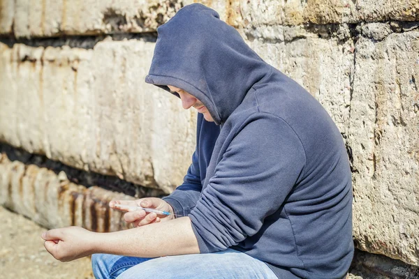 Hombre drogadicto con jeringa cerca de la mano al aire libre —  Fotos de Stock