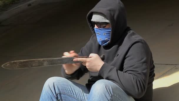 Man scherpt de machete op buiten — Stockvideo