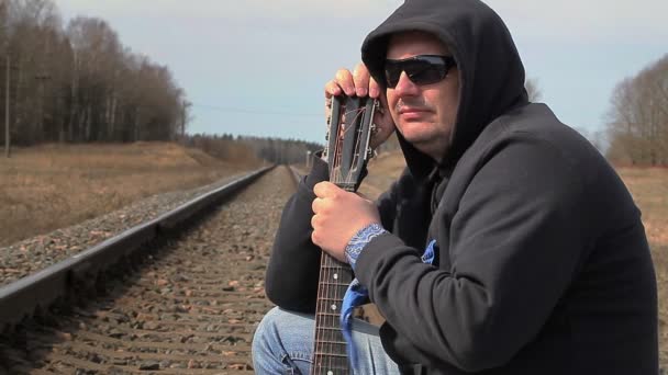 Ensam Man med gitarr på järnvägen — Stockvideo