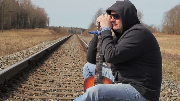 Mannen med gitarr på järnvägen — Stockvideo