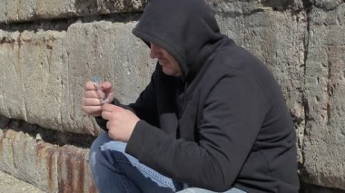 Uyuşturucu bağımlısı adam şırınga ile el duvara yakın