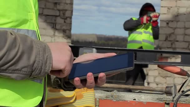 İnşaat işçisi ile tablet Pc bitmemiş binaya — Stok video