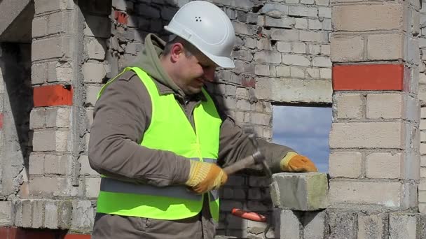 Obrero de la construcción con mazo y ladrillo — Vídeo de stock