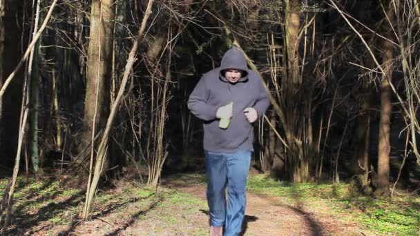 Boisson de coureur fatigué de la bouteille et vérifier l'heure dans le parc — Video