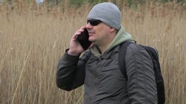 Baston yakınında cep telefonuyla konuşan yürüyüşçü