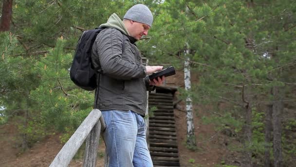 Турист с планшетным ПК в лесу — стоковое видео