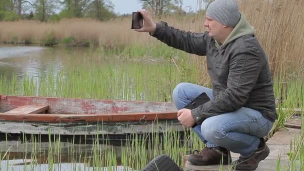 Filmación de excursionistas con tablet PC cerca del lago — Vídeo de stock