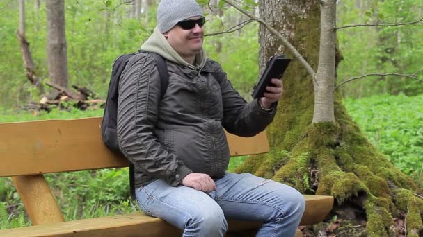 Hiker with tablet PC in park — Stock Video