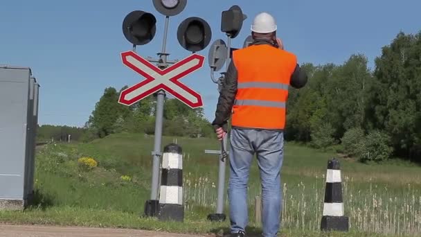 Arbetstagare med mobiltelefon nära järnvägen — Stockvideo