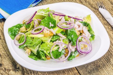 Beyaz tabakta karidesli Sezar salatası