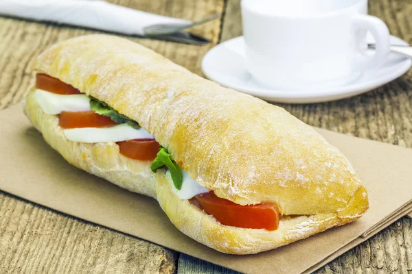 Filled baguette with mozzarella cheese on table — Stockfoto