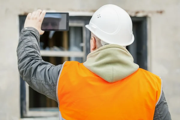 Inspetor de construção com tablet PC perto do edifício — Fotografia de Stock