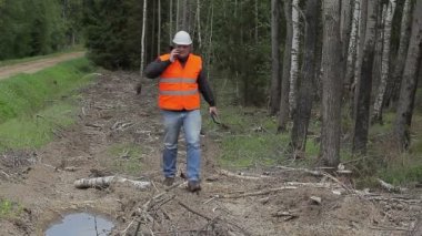 Orman mühendisi orman yakın cep telefonuyla konuşuyor