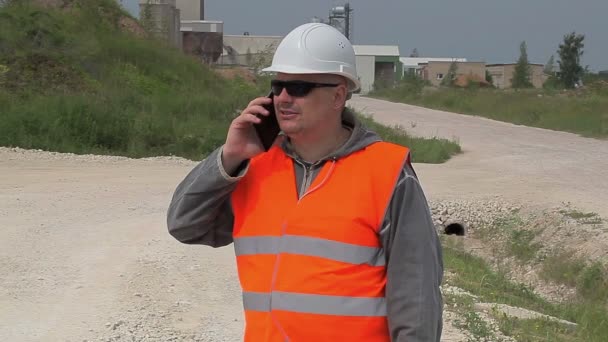 Ingenieur praten op mobiele telefoon in de buurt van fabriek — Stockvideo