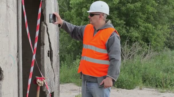 Engenheiro de construção perto do edifício filmado com tablet PC — Vídeo de Stock